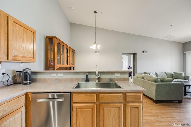 kitchen featuring visible vents, dishwasher, light wood-type flooring, lofted ceiling, and a sink