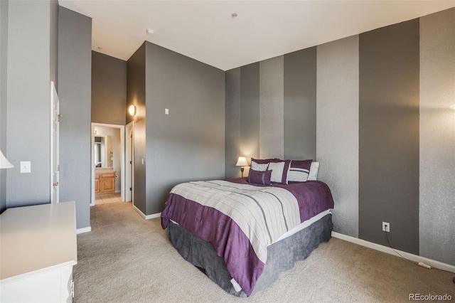 bedroom with carpet, baseboards, and ensuite bathroom