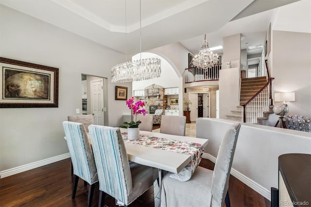 dining room with a towering ceiling and dark hardwood / wood-style floors