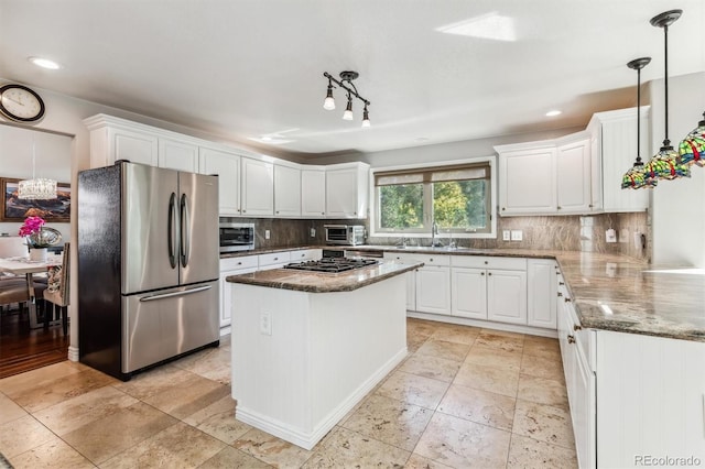 kitchen with pendant lighting, stainless steel appliances, white cabinetry, and a kitchen island