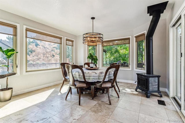 dining room with a notable chandelier and a wood stove