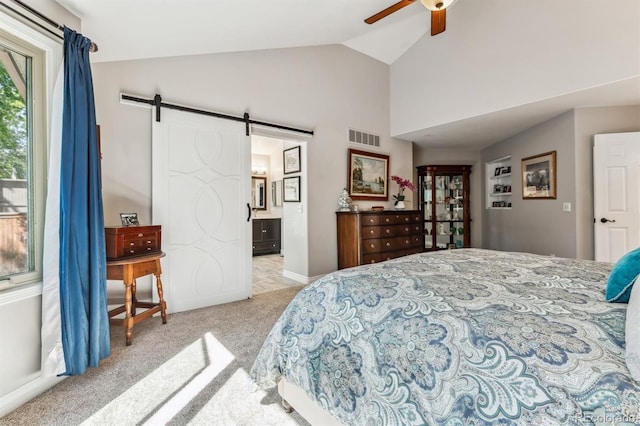 carpeted bedroom featuring ensuite bath, ceiling fan, vaulted ceiling, and a barn door