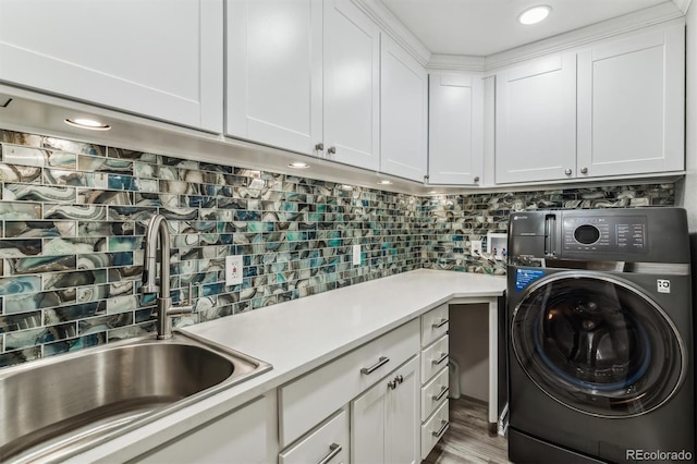 washroom with cabinets, light hardwood / wood-style flooring, sink, and washer / dryer