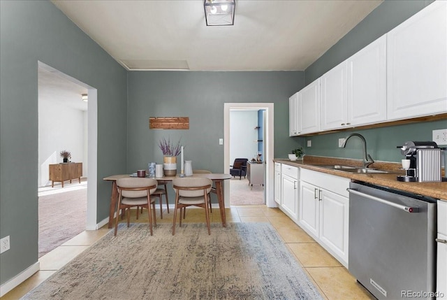 3300 W 2nd Ave, Denver, CO 80219 - kitchen with dishwasher, light tile patterned floors, and white cabinetry