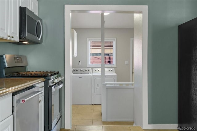 3300 W 2nd Ave, Denver, CO 80219 - kitchen with appliances with stainless steel finishes, separate washer and dryer, white cabinetry, and light tile patterned floors