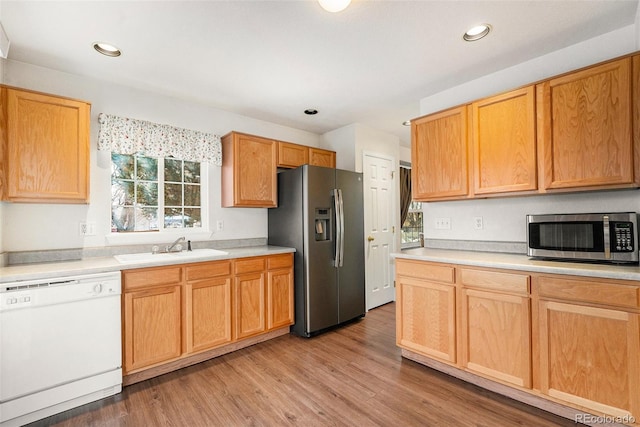 kitchen with sink, appliances with stainless steel finishes, and light wood-type flooring