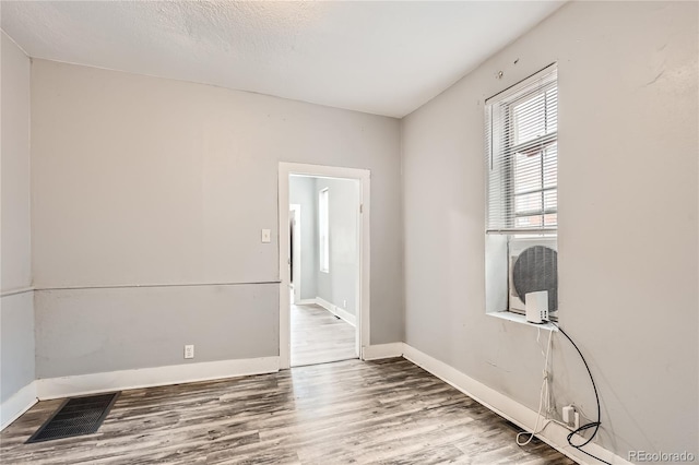 empty room featuring hardwood / wood-style floors and a textured ceiling