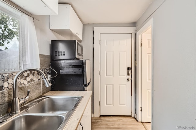 kitchen featuring sink, white cabinets, and light hardwood / wood-style floors