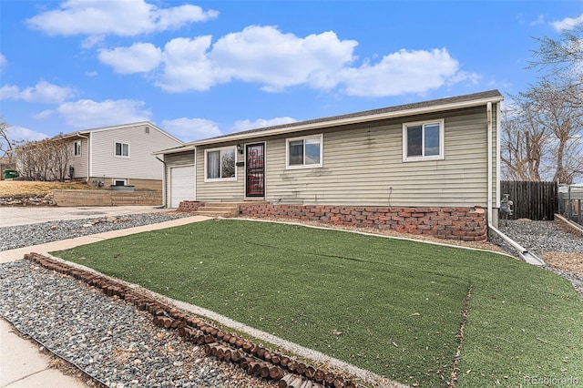 single story home featuring a front yard, fence, and driveway