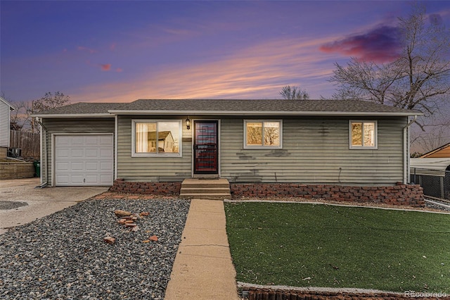 ranch-style house featuring a lawn, driveway, and a garage