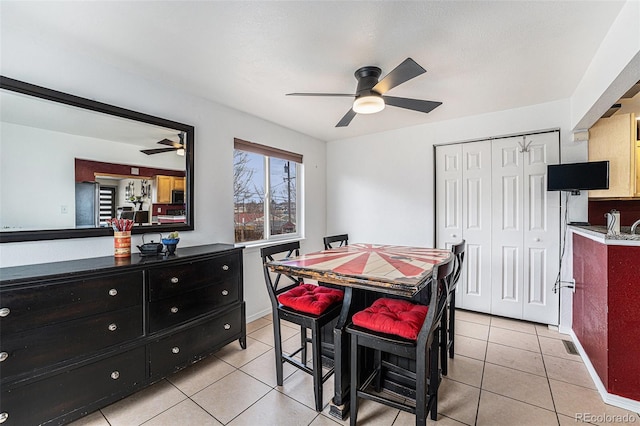 dining space featuring light tile patterned floors, baseboards, and a ceiling fan