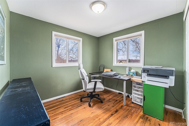 home office featuring a healthy amount of sunlight, baseboards, and wood finished floors