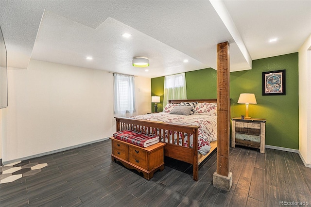 bedroom with a textured ceiling, baseboards, and wood finished floors