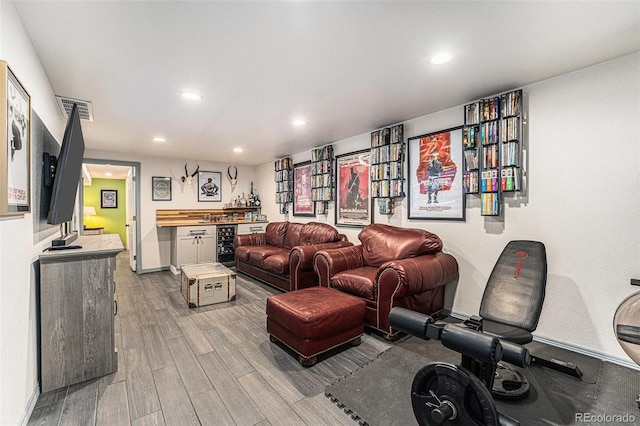 living area with a dry bar, beverage cooler, visible vents, wood finished floors, and recessed lighting