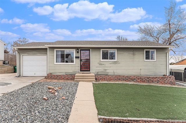 ranch-style home featuring a shingled roof, concrete driveway, an attached garage, a front yard, and fence