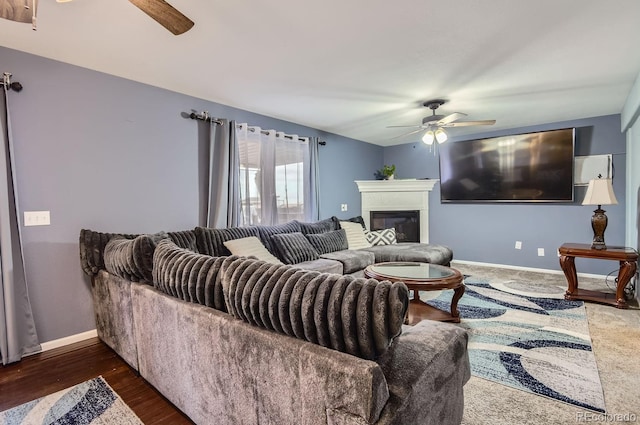 living room featuring dark wood-type flooring and ceiling fan