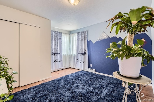 bedroom featuring hardwood / wood-style floors, a closet, and a textured ceiling