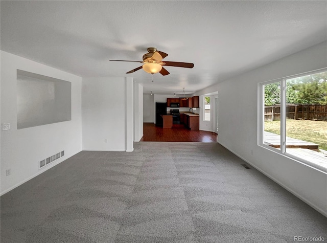 12550 Eastlake Dr, Thornton, CO 80241 - unfurnished living room featuring ceiling fan, dark colored carpet, baseboards, and a sink
