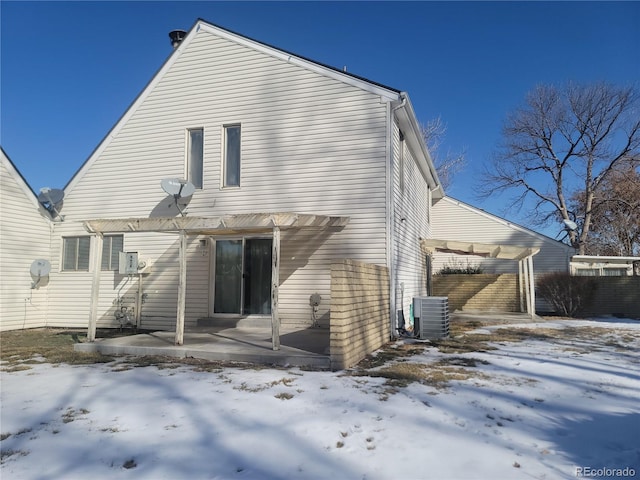 snow covered house with a pergola and central AC