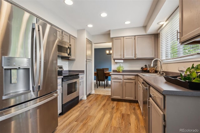 8268 W Caley Pl, Littleton, CO 80123 - kitchen featuring stainless steel appliances, a sink, light wood-style floors, dark countertops, and recessed lighting