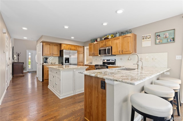 1774 Spring Water Pl, Highlands Ranch, CO 80129 - kitchen featuring stainless steel appliances, a sink, wood finished floors, light stone counters, and decorative backsplash