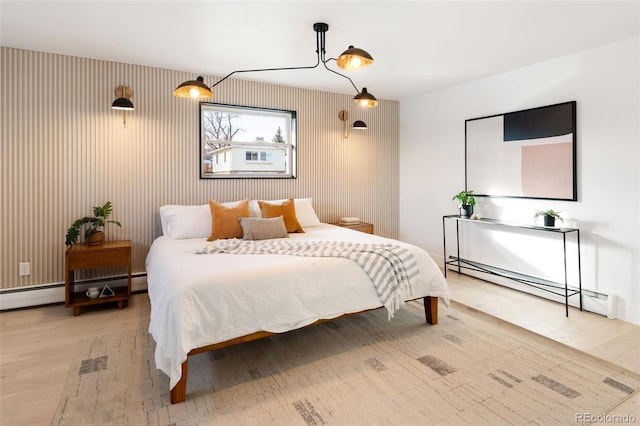 bedroom featuring light wood-type flooring and baseboard heating