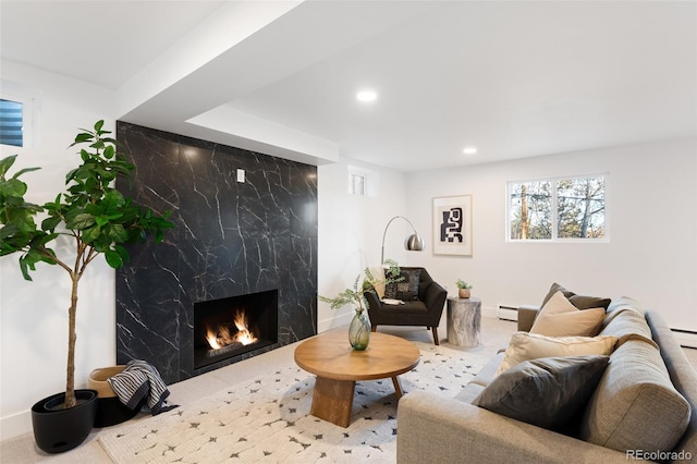 living room with baseboard heating and a high end fireplace