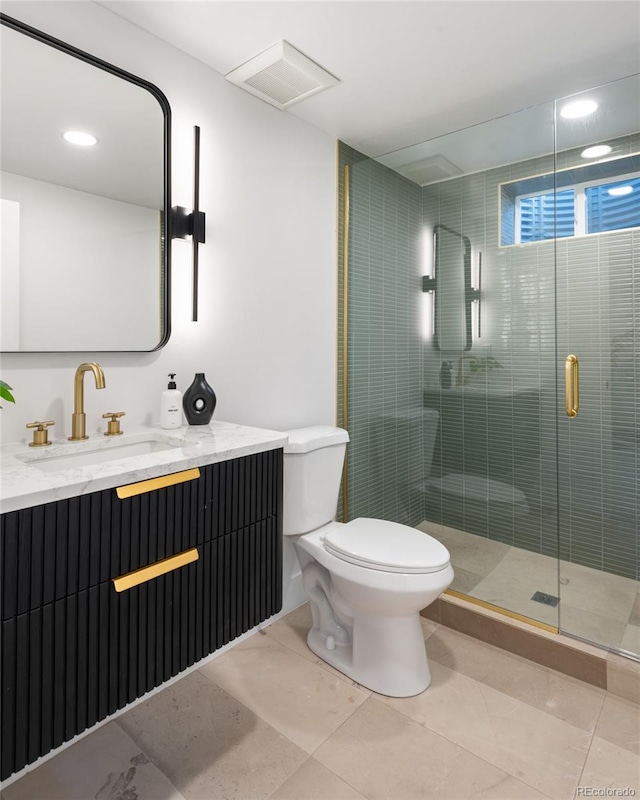 bathroom with tile patterned floors, vanity, an enclosed shower, and toilet