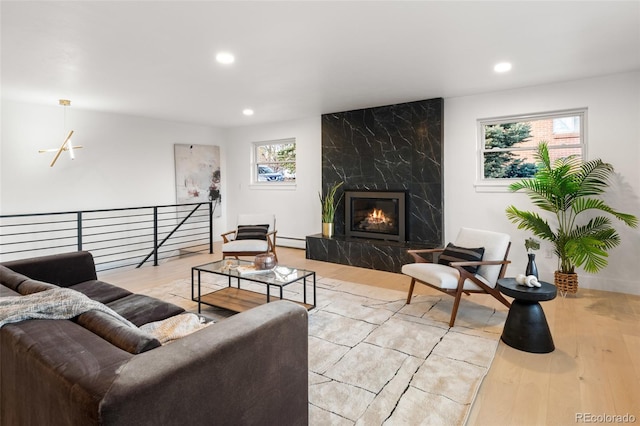 living room featuring plenty of natural light, a fireplace, and light hardwood / wood-style flooring