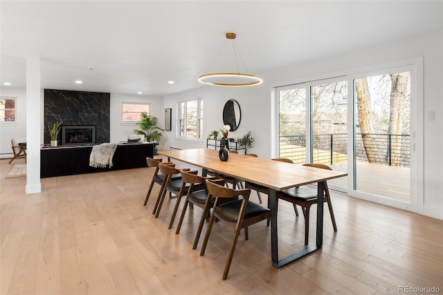 dining space with a fireplace and light wood-type flooring