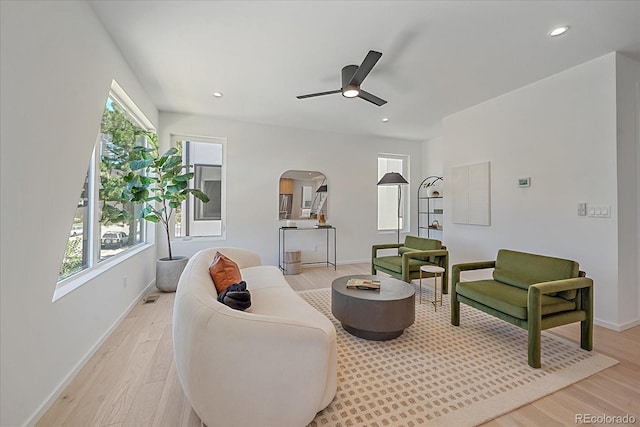 living room with ceiling fan, a wealth of natural light, and light hardwood / wood-style floors