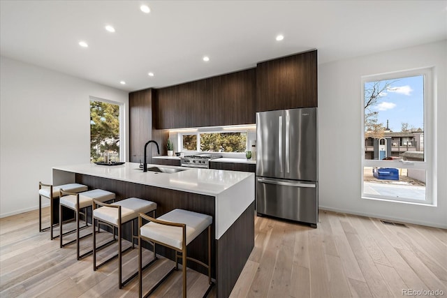 kitchen featuring sink, appliances with stainless steel finishes, a breakfast bar area, and a healthy amount of sunlight