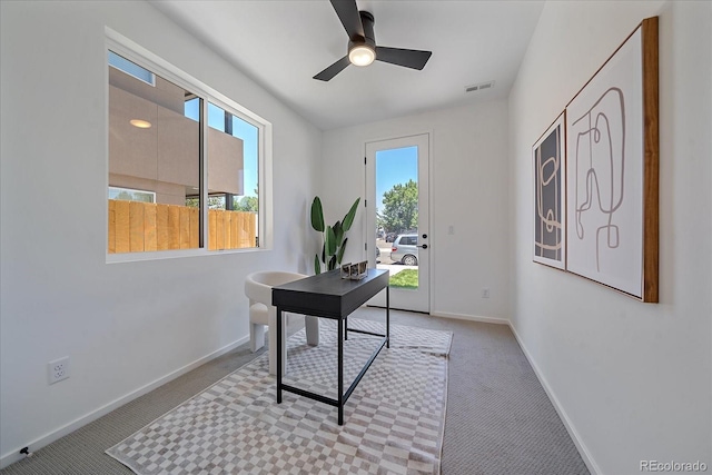 carpeted home office featuring ceiling fan and a healthy amount of sunlight