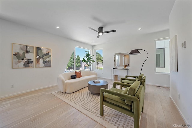 living room featuring ceiling fan and light hardwood / wood-style floors