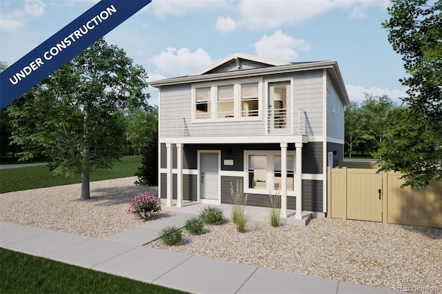 view of front of house with a balcony, fence, and a porch