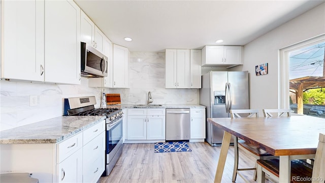 1741 W 55th Pl, Denver, CO 80221 - kitchen with stainless steel appliances, white cabinetry, light stone counters, and recessed lighting