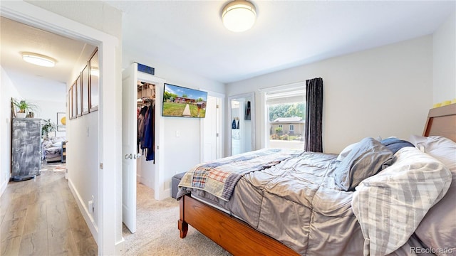 1741 W 55th Pl, Denver, CO 80221 - bedroom featuring light wood-style flooring, a closet, and a walk in closet