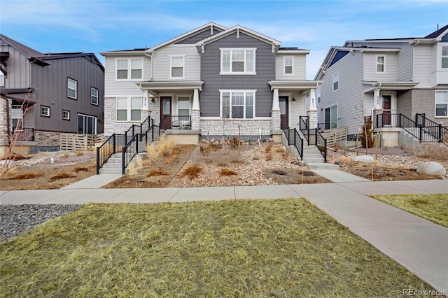 view of front of house featuring stone siding and a front yard