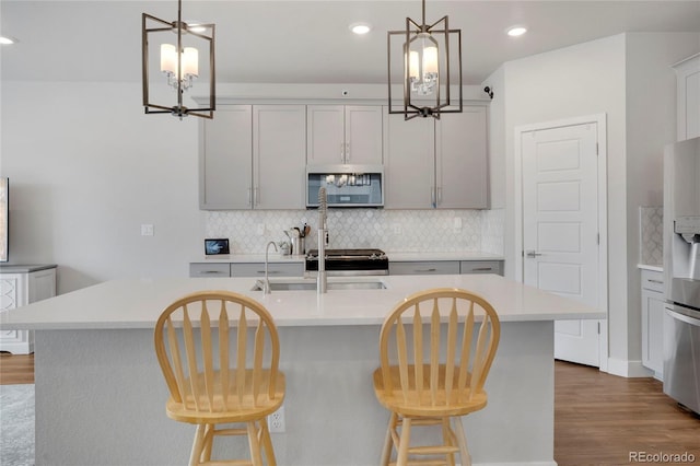 kitchen featuring stainless steel appliances, tasteful backsplash, and light countertops