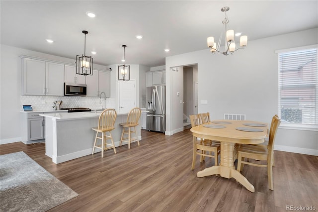 dining area featuring baseboards, wood finished floors, and recessed lighting