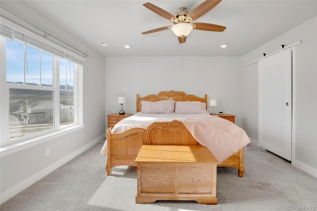 bedroom with recessed lighting, visible vents, a barn door, light carpet, and baseboards