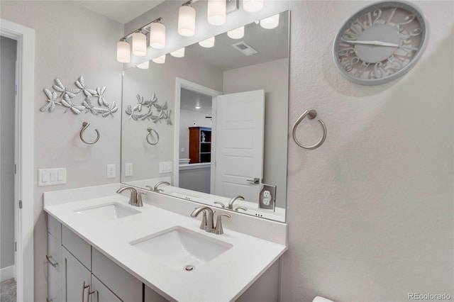 bathroom featuring double vanity, visible vents, and a sink