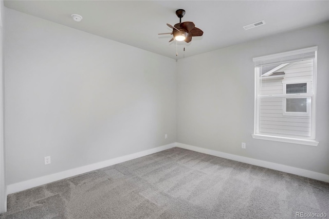 empty room with carpet floors, visible vents, baseboards, and a ceiling fan