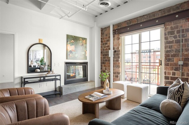 1435 Wazee St Unit 305, Denver, CO 80202 - living area featuring a glass covered fireplace, wood finished floors, and brick wall