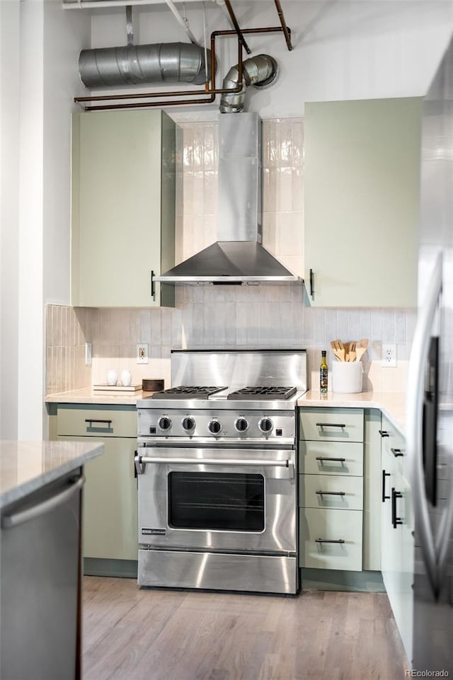 1435 Wazee St Unit 305, Denver, CO 80202 - kitchen with wall chimney exhaust hood, stainless steel appliances, green cabinetry, and backsplash