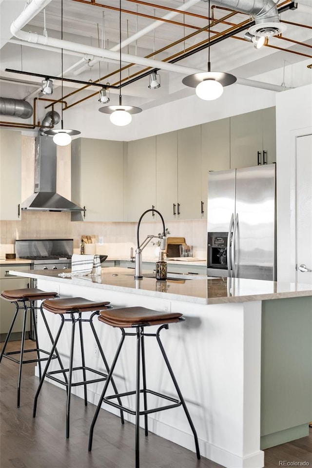 1435 Wazee St Unit 305, Denver, CO 80202 - kitchen featuring stainless steel fridge, wall chimney exhaust hood, backsplash, dark wood finished floors, and hanging light fixtures