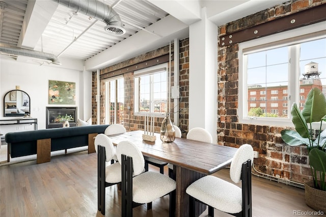 1435 Wazee St Unit 305, Denver, CO 80202 - dining space featuring brick wall, plenty of natural light, and wood finished floors
