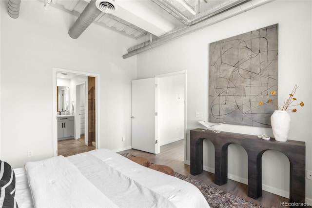 1435 Wazee St Unit 305, Denver, CO 80202 - bedroom with a high ceiling, ensuite bathroom, and wood finished floors