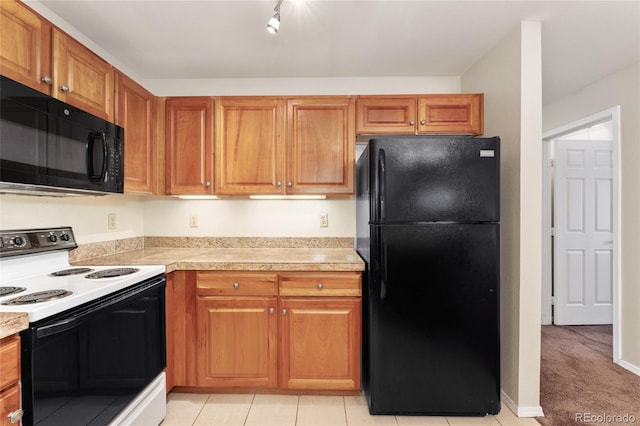 kitchen with light tile patterned flooring and black appliances