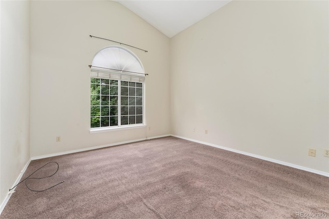 carpeted empty room with high vaulted ceiling